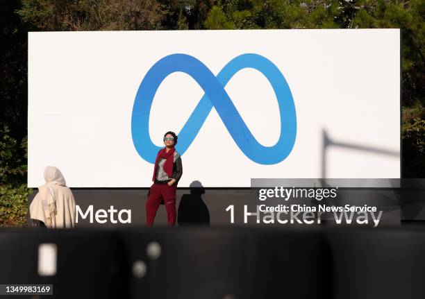 People take pictures in front of a sign showing logo of Meta outside Facebook headquarters on October 28, 2021 in Menlo Park, California.