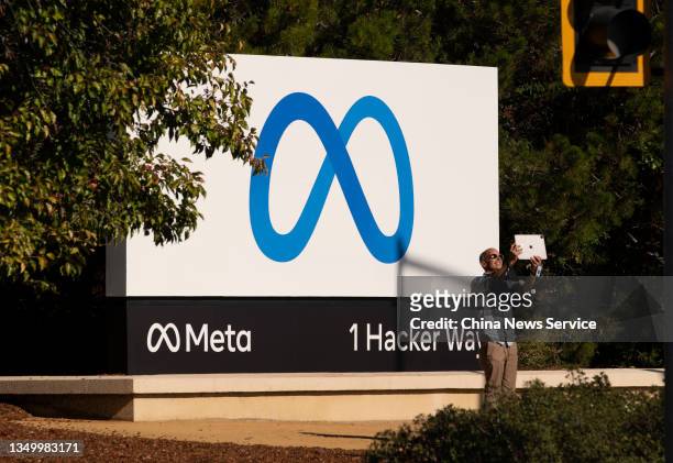 Man takes pictures in front of a sign showing logo of Meta outside Facebook headquarters on October 28, 2021 in Menlo Park, California.
