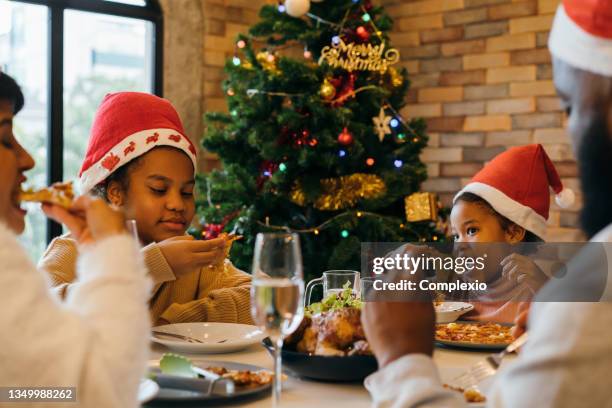 family enjoying christmas dinner at home - december 6 stock pictures, royalty-free photos & images