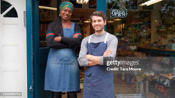 two owners standing outside shop - open sign stock pictures, royalty-free photos & images