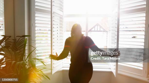 woman at window in house - sunny window stock pictures, royalty-free photos & images