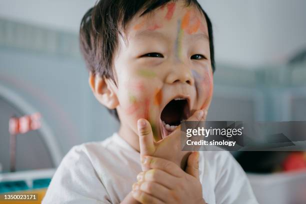little asian girl drawing in home - baby paint stock-fotos und bilder