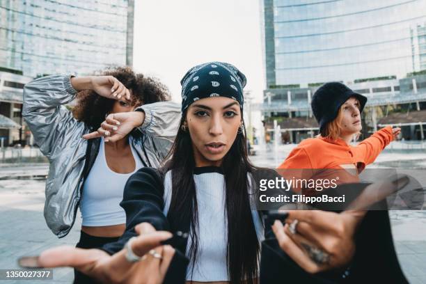 drei befreundete tänzerinnen posieren in einer modernen stadt - fashion magazine cover stock-fotos und bilder