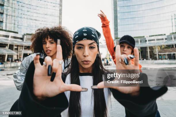 three female dancer friends are posing in a modern city - rap stockfoto's en -beelden