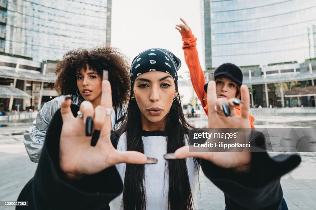 Three female dancer friends are posing in a modern city
