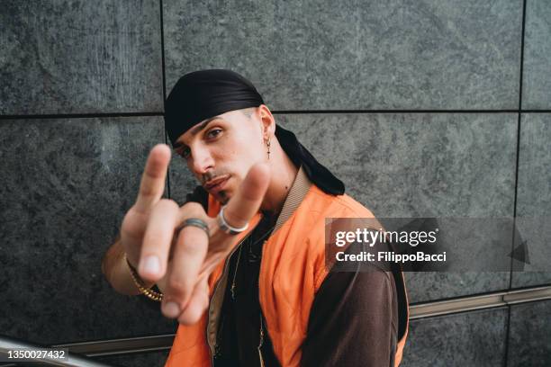 portrait of a young adult man wearing cool urban clothes in the city - white rapper stock pictures, royalty-free photos & images