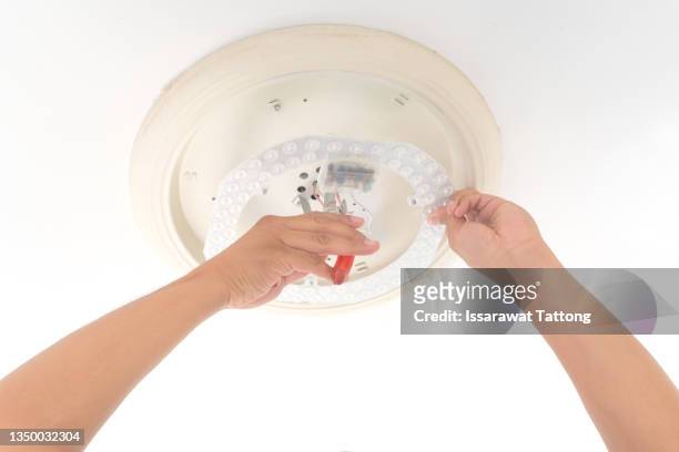man changing light led bulb in lamp - recessed lighting ceiling 個照片及圖片檔