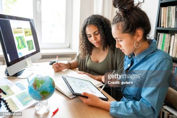 two young woman working together on concepts for climate protection - research stock pictures, royalty-free photos & images
