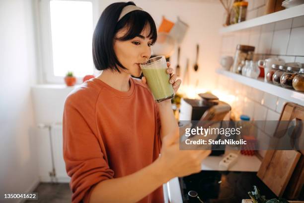 beautiful woman drinking a green detox juice s - smoothie and woman stockfoto's en -beelden