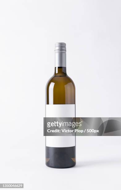 close-up of oil in bottle against white background - wine bottle stock pictures, royalty-free photos & images