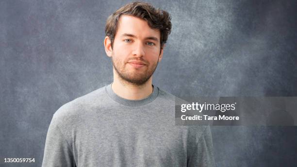 portrait of young man against grey background - mottled stock pictures, royalty-free photos & images