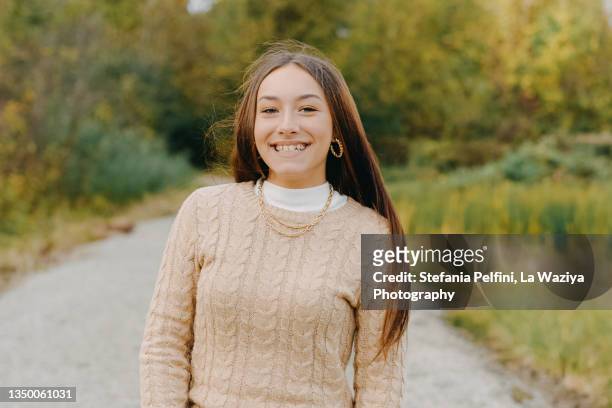 beautiful teenager girl smiling at the camera while in nature - mock turtleneck foto e immagini stock