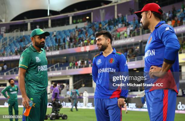 Babar Azam of Pakistan interacts with Rashid Khan and Mohammad Nabi of Afghanistan following the ICC Men's T20 World Cup match between Pakistan and...