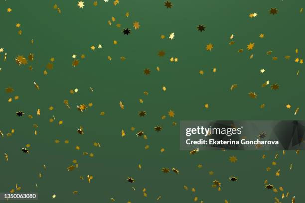 a bunch of gold stars on a green background. - confetti gold ストックフォトと画像