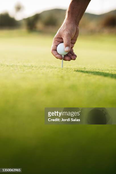 golfer's gloved hand teeing up - golf tee stock pictures, royalty-free photos & images