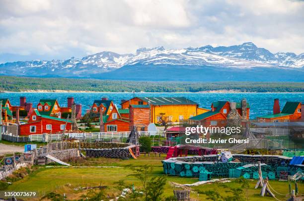 casas de madera y montañas de fondo. lago fagnano, tolhuin, tierra del fuego, patagonia argentina. - noord zuid amerika stockfoto's en -beelden
