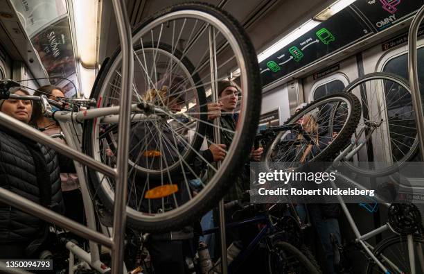 Five cyclists hold their bicycles while riding a downtown subway October 29, 2021 in New York City. It is estimated there are over 800,000 bicyclists...