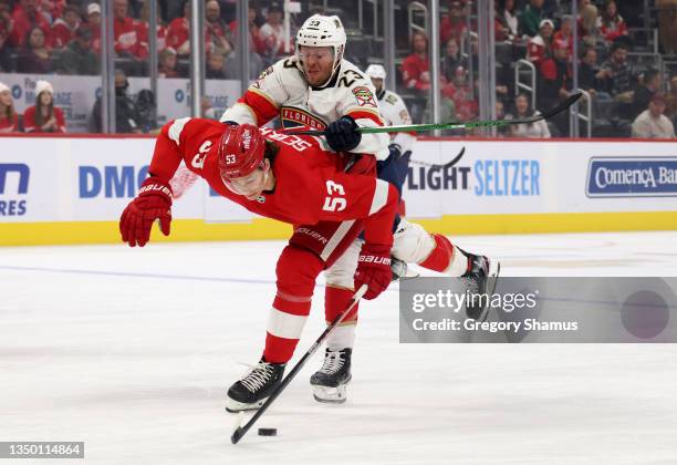 Moritz Seider of the Detroit Red Wings battles for the puck with Carter Verhaeghe of the Florida Panthers during the first period at Little Caesars...