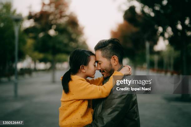 japanese father and young daughter hugging at dusk - asian father and daughter stock pictures, royalty-free photos & images