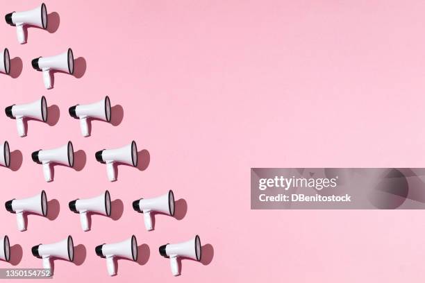 white megaphones pattern with black ornament on pink background on the left side, with copy space. shout, message, announcement and news concept. - concentration bildbanksfoton och bilder