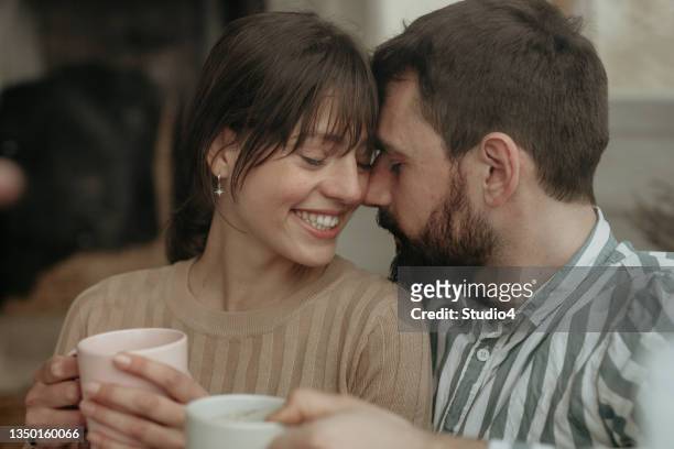 couple drinking coffee by the window - enjoying coffee cafe morning light stock pictures, royalty-free photos & images