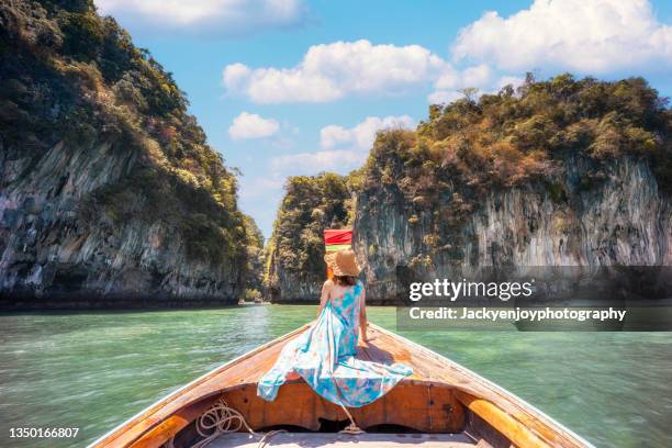 one tourist woman sitting on a longtail boat in maya bay, phi phi islands, thailand - phi phi island stock pictures, royalty-free photos & images