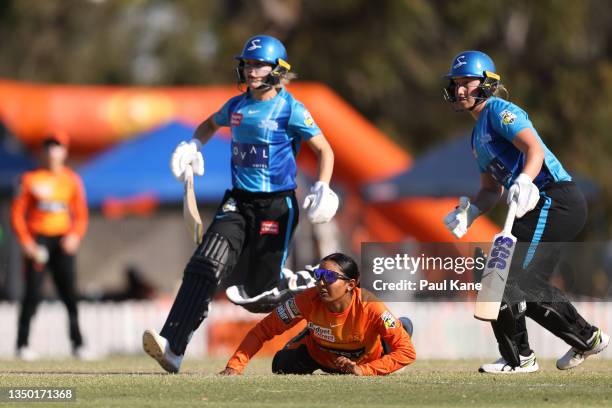 Alana King of the Scorchers looks on from the pitch as Bridget Patterson and Madeline Penna of the Strikers are involved in a run-out during the...