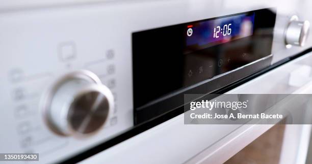 buttons and control panel of a modern oven with the clock timer flashing. - oven knobs stock pictures, royalty-free photos & images