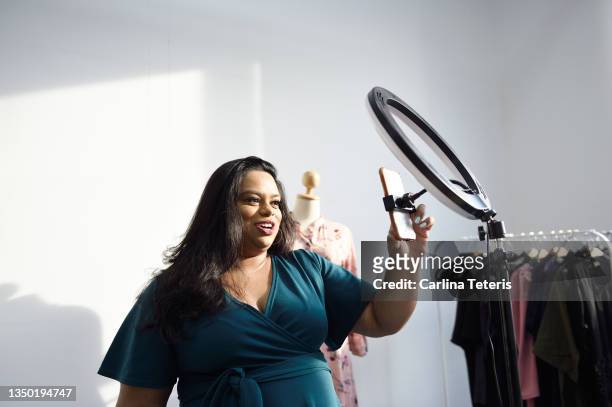 woman setting up a mobile phone and ring light - beautiful east indian women stockfoto's en -beelden