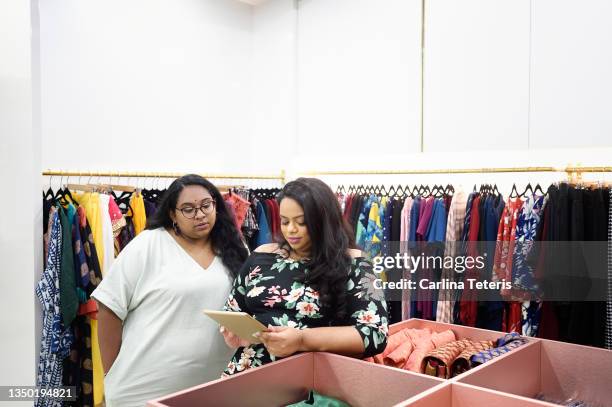 woman training her employee on a tablet - chubby man shopping stock-fotos und bilder