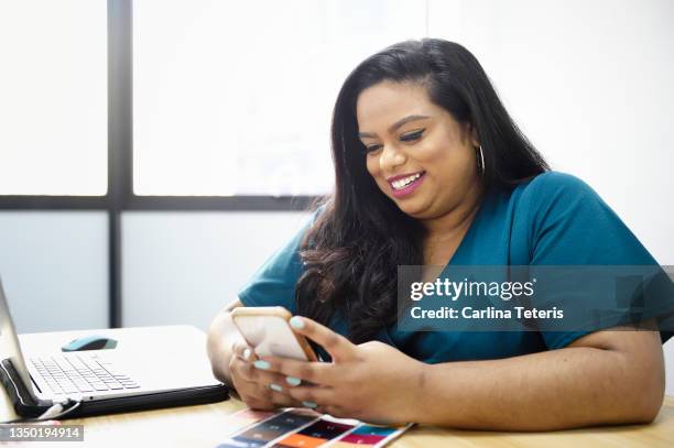 woman using her mobile phone at her desk - showus office stock pictures, royalty-free photos & images