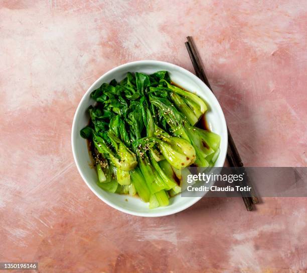 bowl of bok choy salad on peach background - chinese cabbage stock pictures, royalty-free photos & images