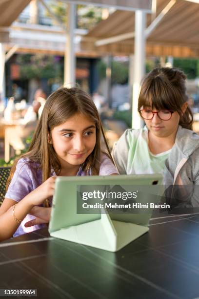 belle ragazze che usano il tablet digitale all'aperto - famiglia multimediale foto e immagini stock