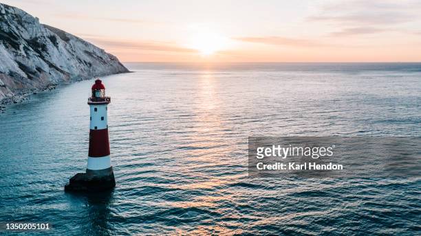 the white cliffs of east sussex and beachy head lighthouse at sunrise - stock photo - beachy head stockfoto's en -beelden