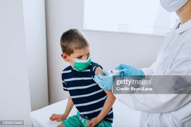 child receiving vaccination shot from doctor - receiving treatment concerned stock pictures, royalty-free photos & images