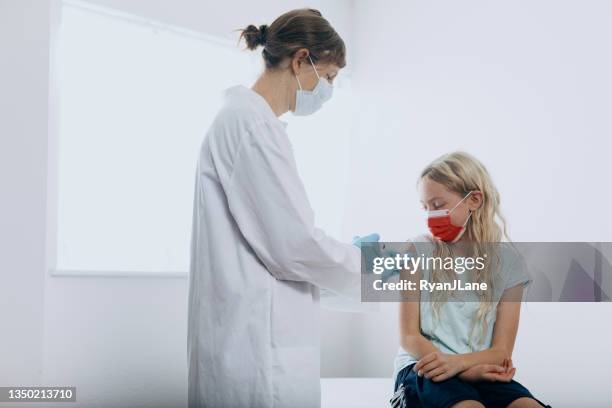 child receiving vaccination shot from doctor - receiving treatment concerned stock pictures, royalty-free photos & images