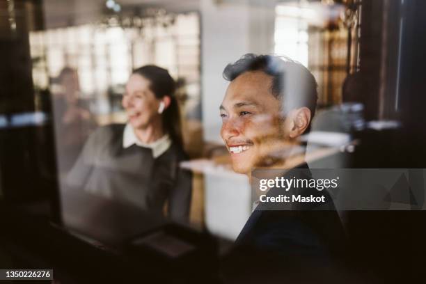 laughing male and female professional seen through glass - employee engagement stock pictures, royalty-free photos & images