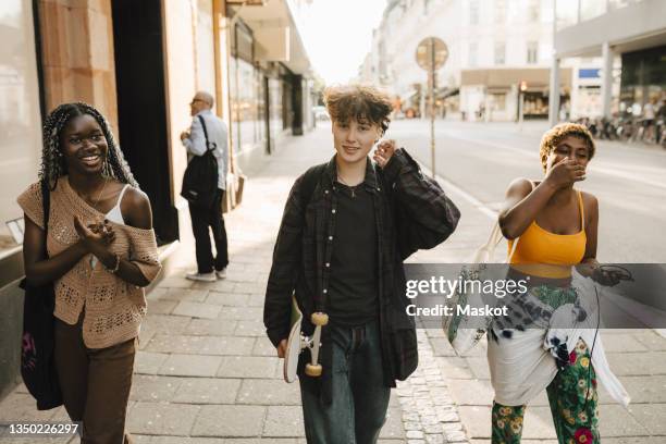 portrait of teenage boy walking with friends on footpath - skane stock pictures, royalty-free photos & images