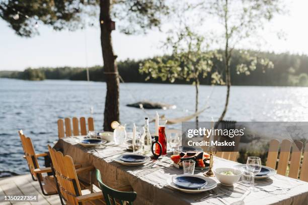 dining table by lake on sunny day - summer dinner party stock pictures, royalty-free photos & images