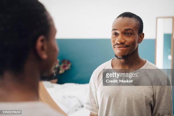 smiling mid adult man looking in mirror - spiegel stock-fotos und bilder