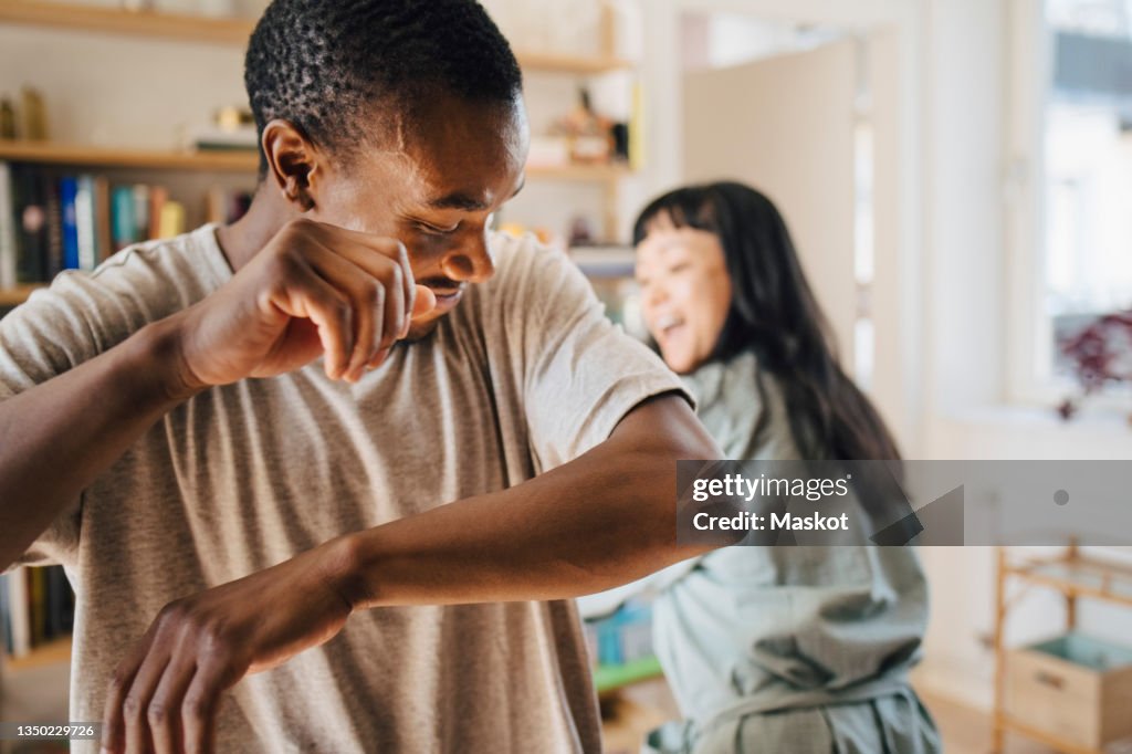 Mid adult man dancing with girlfriend at home