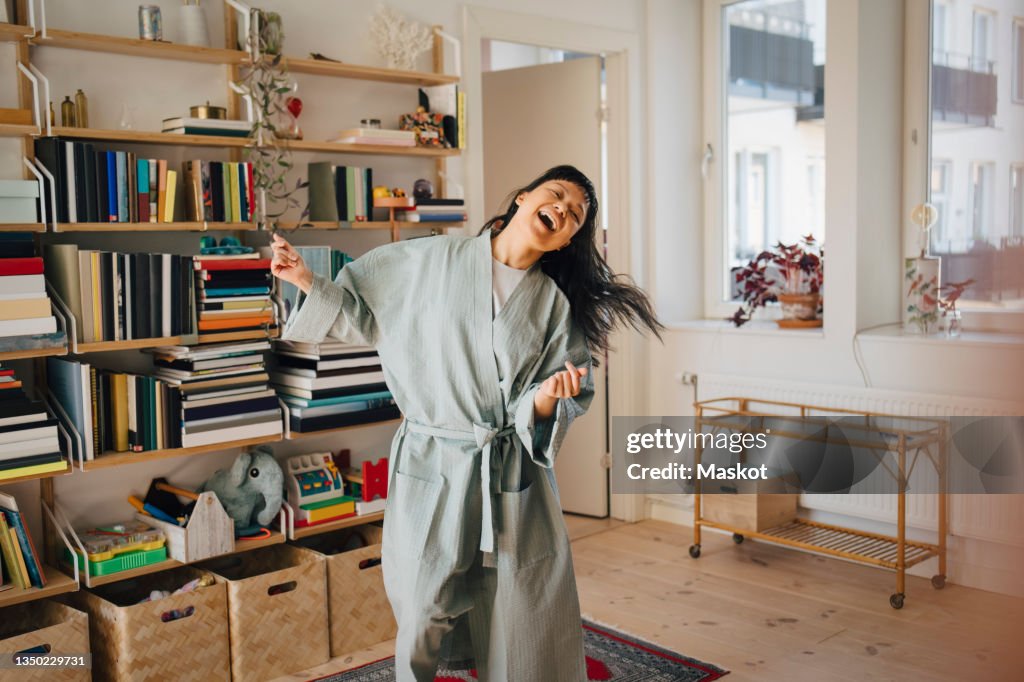 Cheerful woman enjoying while dancing at home