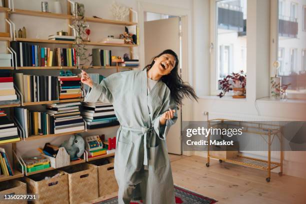 cheerful woman enjoying while dancing at home - robe stock pictures, royalty-free photos & images