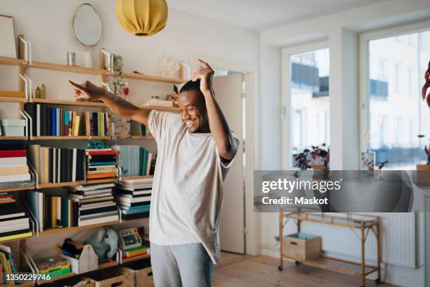 happy man dancing in living room at home - bailar fotografías e imágenes de stock