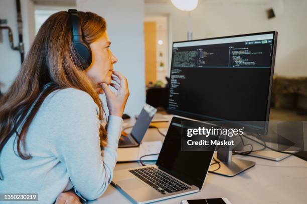 mature female hacker brainstorming while coding over computer in office - code 41 bildbanksfoton och bilder