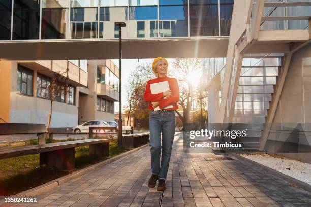 curiosa estudiante universitaria moderna que explora el campus - mirar alrededor fotografías e imágenes de stock