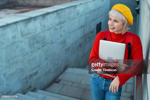 at the campus, stem female university student resting on the staircase - om zich heen kijken stockfoto's en -beelden