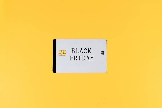 White credit card with the word 'Black Friday', on yellow background. Black Friday, shopping, commerce and credit cards concept.