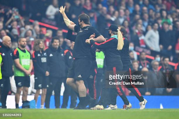 Pitch invader is escorted off the pitch by security during the Autumn International match between Wales and New Zealand at Principality Stadium on...