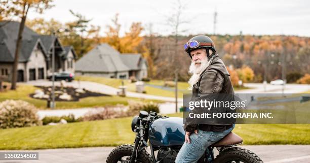senior man getting ready to ride his motorcycle - old garage at home stock pictures, royalty-free photos & images